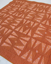 Load image into Gallery viewer, The Carpe Diem quilt - with its twist on the traditional hourglass block and its symbolism of time - serves as a reminder that the future is never guaranteed; and yet, what we do with the present shapes our tomorrow. By holding and reconciling these seemingly contradicting truths, we can work toward finding purpose, hope & joy in each day. Available at globalfibershop.com.