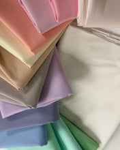 Load image into Gallery viewer, Stack of colorful fabric swatches in various pastel shades.