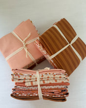 Load image into Gallery viewer, Folded fabric bundles tied with string on a light background