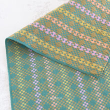 Load image into Gallery viewer, Close-up of a woven fabric. Embrace the charm of the rainbow with Fableism Supply Co’s ‘Lucky Loom’ fabric collection—a dazzling fusion of mixed weight wovens inspired by moments of serendipity. This collection’s palette radiates warmth and whimsy, featuring golden yellows, soft pinks, earthy greens, tranquil blues, and rich purples, each reminiscent of the colors in a lucky rainbow. Available at globalfibershop.com.