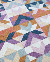 Load image into Gallery viewer, Quilt with a geometric pattern of triangles in various colors.