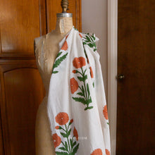Load image into Gallery viewer, Block printed fabric with orange floral patterns on a white background. Available at globalfibershop.com.