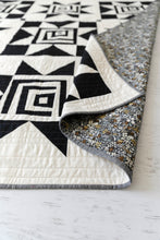 Load image into Gallery viewer, Black and White Shining Star quilt kit for Suzy Quilts sold at Global Fiber Shop. Metallic floral print backing sneak peek.