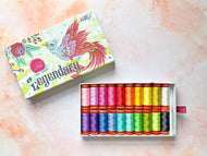 Rainbow assortment of Aurifil thread spools in a decorative Legendary box. Curated by Tula Pink for Aurifil. Available at globalfibershop.com.