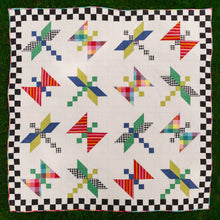 Load image into Gallery viewer, Colorful quilt with geometric pattern on a checkered border. Dragonfly Lake Quilt in Picnic Wovens by Suzy Quits for Art Gallery Fabrics. Available at globalfibershop.com
