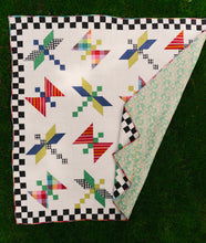 Load image into Gallery viewer, Colorful quilt with geometric pattern on a checkered border. Dragonfly Lake Quilt in Picnic Wovens by Suzy Quits for Art Gallery Fabrics. Available at globalfibershop.com
