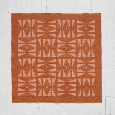 The Carpe Diem quilt - with its twist on the traditional hourglass block and its symbolism of time - serves as a reminder that the future is never guaranteed; and yet, what we do with the present shapes our tomorrow. By holding and reconciling these seemingly contradicting truths, we can work toward finding purpose, hope & joy in each day. Available at globalfibershop.com.