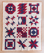 Load image into Gallery viewer, Quilt with red and blue geometric patterns on a beige background
