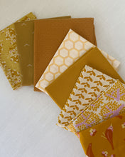 Load image into Gallery viewer, Collection of patterned fabric squares in shades of brown and orange on a light background
