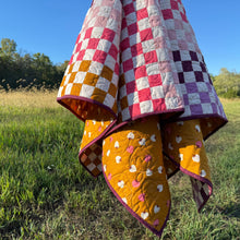 Load image into Gallery viewer, Colorful quilt draped over a chair in a grassy field with trees in the background
