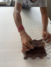 Load image into Gallery viewer, Person using a wooden stamp on a textured surface with a blurred background. Indian Block Prints from Fableism available at globalfibershop.com.
