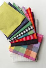 Load image into Gallery viewer, Stack of colorful fabric swatches on a white background. Picnic Wovens by Suzy Quilts for Art Gallery Fabrics, available at globalfibershop.com.
