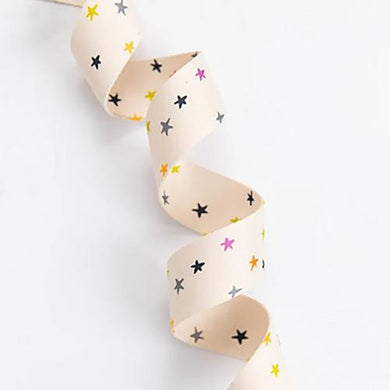 Beige ribbon with colorful star pattern on a white background. We are now stocking fun and flirty webbing, designed by your favorite Ruby Star Society designers for Stitch Supply Co. Available at globalfibershop.com.