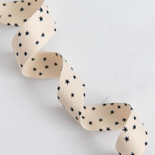 Cream ribbon with mini black stars. Designed by Ruby Star Society and sold by globalfibershop.com.
