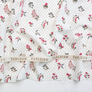 Floral fabric with a ribbon displaying 'Fableism' on a textured surface