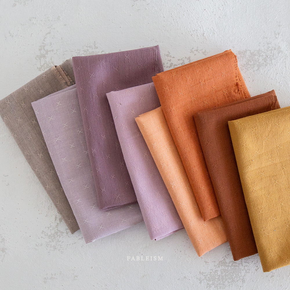 This debut collection from Fableism Supply Company now updated with 8 new shades for Spring 2024. The small woven-X provides just enough texture to elevate this gorgeous substrate to the next level.Available at globalfibershop.com.