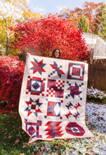 Load image into Gallery viewer, Person holding a red, white, and blue quilt in an outdoor setting with trees and snow.

