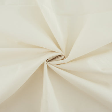 A fabric swatch of Birch Fabrics' Organic Solid poplin in Parchment, pinched and twisted in a fabric swirl.