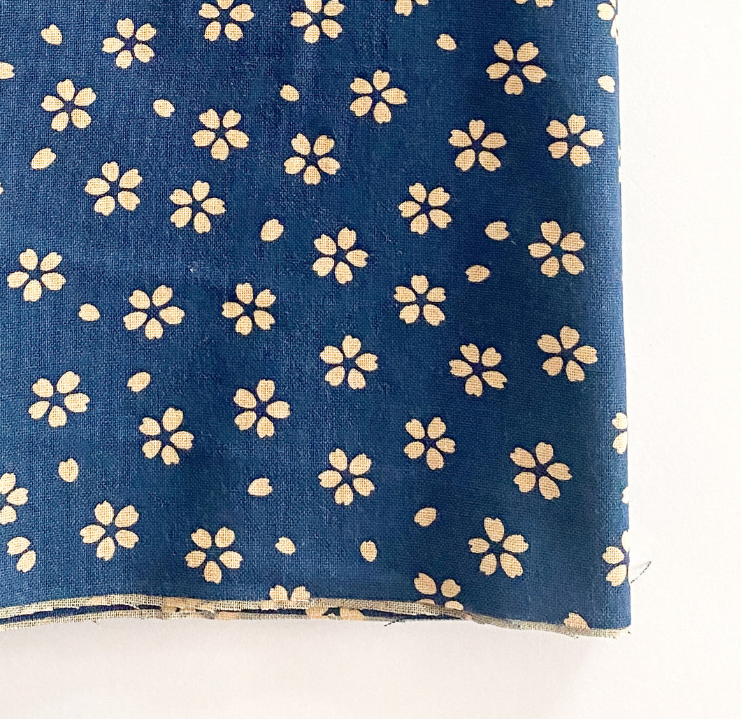 Small neutral ditsy floral print on indigo background by Japanese designer Sevenberry for Robert Kaufman Fabrics.