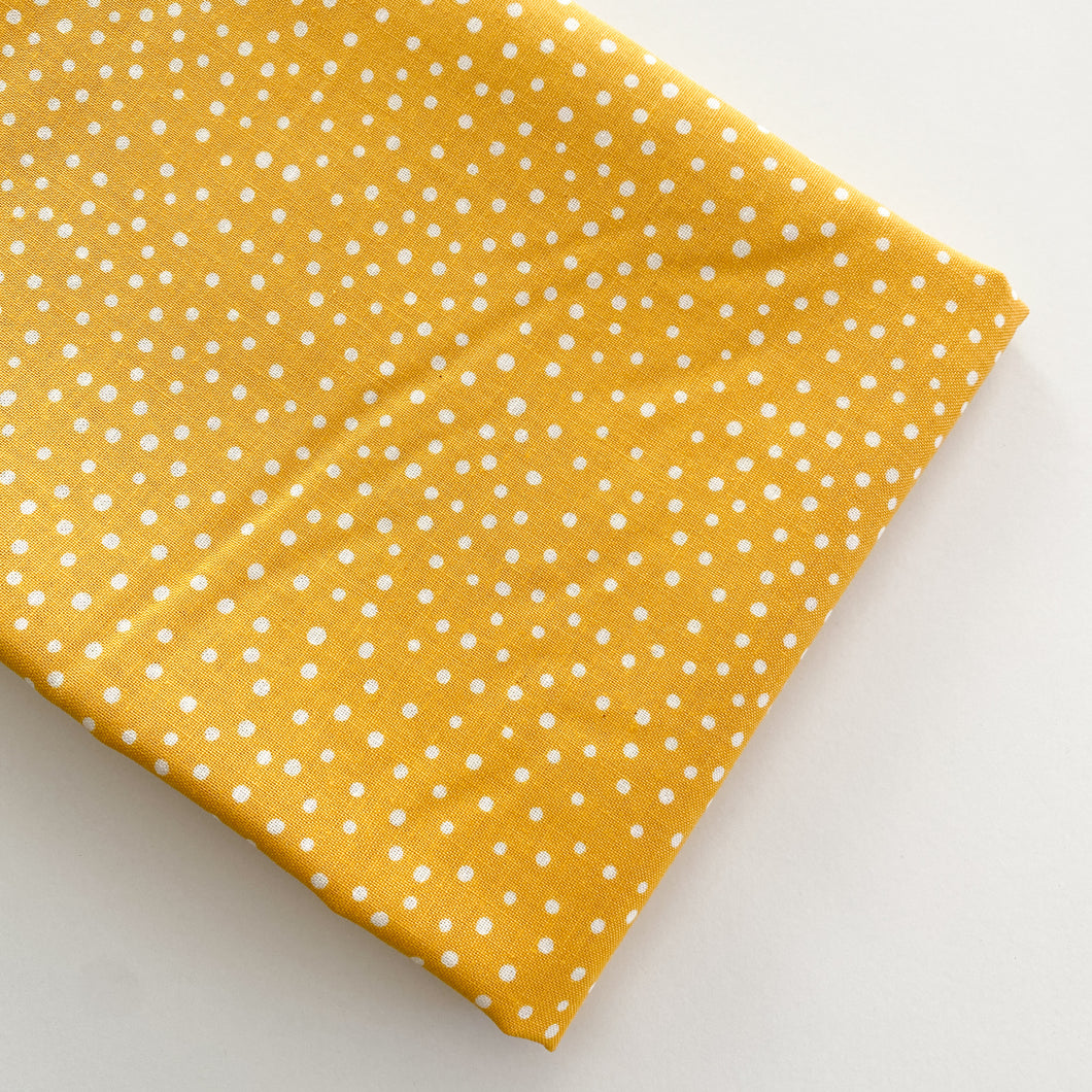 Close up of Happiest Dots in Morning Sun from RJR Fabrics. Happies Dots features organic white polka prints on a background of modern colors.