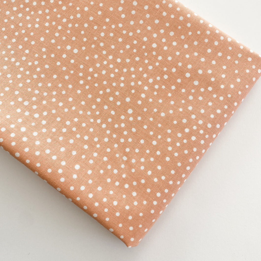 Close up of Happiest Dots in Summer Coral from RJR Fabrics. Happies Dots features organic white polka prints on a background of modern colors.