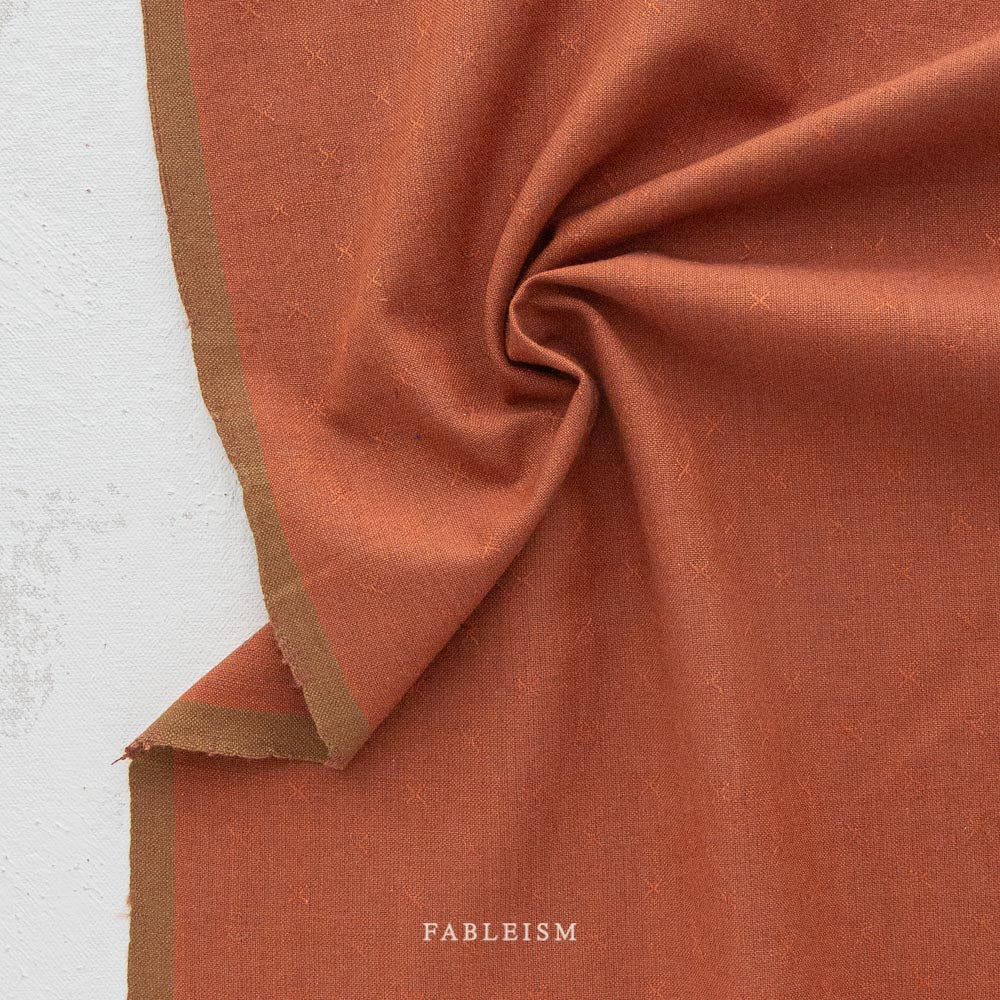 This debut collection from Fableism Supply Company features 28 shades of yarn-dyed wovens in stunning earth tones inspired by natural elements .  The small woven-X provides just enough texture to elevate this gorgeous substrate to the next level. Available at globafibershop.com.